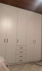 Λευκή ντουλάπα με συρτάρια σε υπνοδωμάτιο